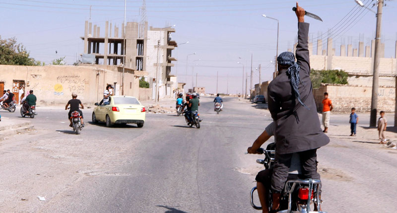 Боевики ИГ* на улице в сирийском городе Табка. Фото: REUTERS/Stringer