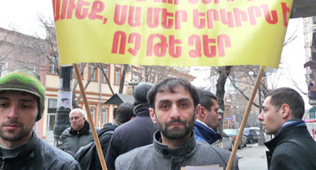 Участник акции в защиту исторических памятников держит плакат с надписью "Власти, остановитесь, это наша страна, а не ваша!". Ереван, 11 февраля 2013 г. Фото Армине Мартиросян для "Кавказского узла"