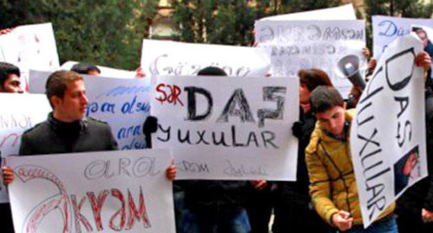 Протест перед домом Акрама Айлисли. Надписи на плакатах (слева направо) - "Ара Акрам", "Клеветнические "Каменные сны" Акрама Айлисли", молодой человек поджигает плакат с надписью "Каменные сны". Баку, 31 января 2013 г. Фото: Turkhan Kerimov (RFE/RL)