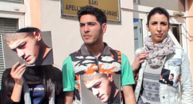 Группа молодежных активистов провела перед зданием апелляционного суда безмолвную акцию протеста, прикрепив к своей одежде фото Мамеда Азизова. Баку, 27 февраля 2013 г. Фото Парваны Байрамовой для "Кавказского узла"