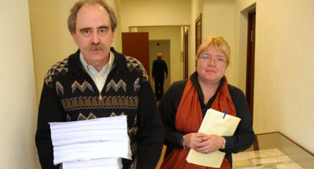 Cопредседатель московского общества "Мемориал" Ян Рачинский и Исполнительный директор "Международного Мемориала" Елена Жемкова выносят документы для проверяющих. Фото: Артём Хан (Deutsche Welle)