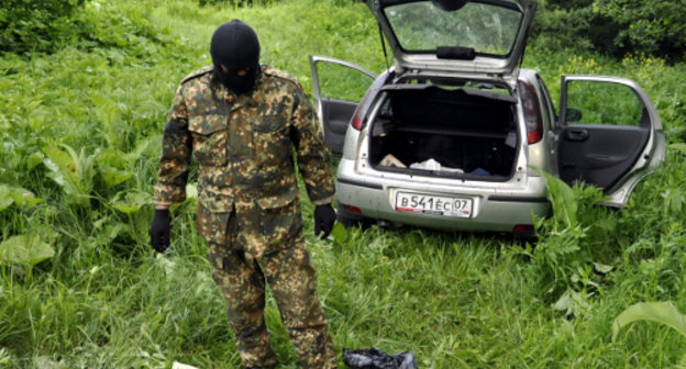 Сотрудник спецслужб у автомобиля, принадлежавшего одному из погибших в ходе перестрелки в Черекском районе КБР 1 июня 2013 г. Фото пресс-службы МВД КБР, http://07.mvd.ru
