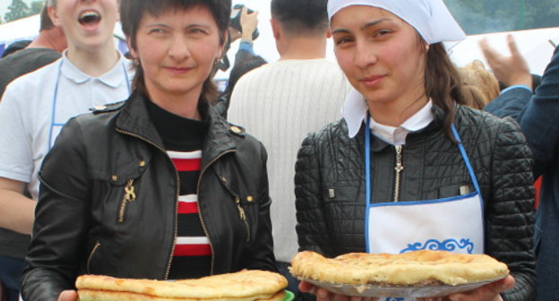 Участники фестиваля осетинских пирогов несут свои произведения для представления жюри. Северная Осетия, Владикавказ, 8 июня 2013 г. Фото Эммы Марзоевой для "Кавказского узла" 