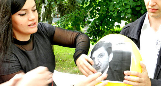 Активистка движения "Волгоградские родители за права детей" наклеивает на воздушные шары портреты представителей власти региона. Волгоград, 20 июня 2013 г. Фото Татьяны Филимоновой для "Кавказского узла"