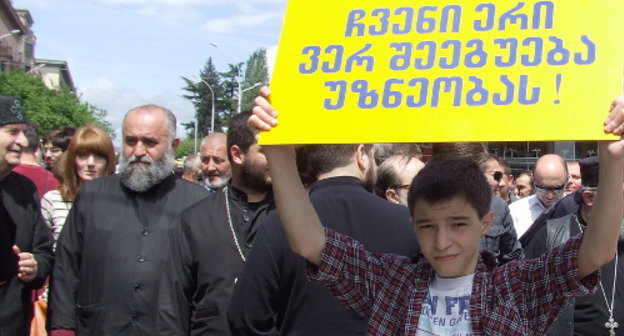 Тбилиси, 17 мая 2013 г. Свяшеннослужители среди участников акции против гей-парадов. Надпись на плакате: "Наша нация не смирится c безнравенностью". Фото Эдиты Бадасян для "Кавказского узла"