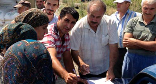 Жители села Храх-Уба, переехавшие в Дагестан, получают гуманитарную помощь от фонда "Чистое сердце". Магарамкентский район, селение Ново-аул, 7 июля 2013 г. Фото: http://xpax.info