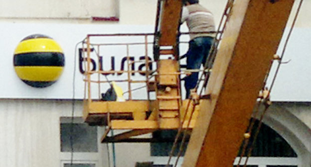 Сотрудник коммунальных служб отмывает здание офиса "Билайна" после атаки хулиганов. 31 августа 2013 г. Фото предоставлено очевидцем