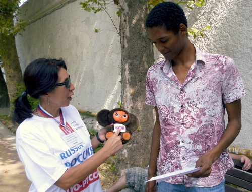 Участница акции с требованием писать название "Россия" на олимпийской форме русскими буквами объясняет прохожему цель мероприятия. Сочи, 3 сентября 2013 г. Фото Светланы Кравченко для "Кавказского узла"