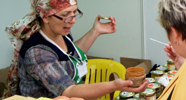 Ярмарка дагестанской продукции на ВВЦ. Продавец предлагает попробовать урбеч. Москва, 31 августа 2013 г. Фото Натальи Крайновой для "Кавказского узла"