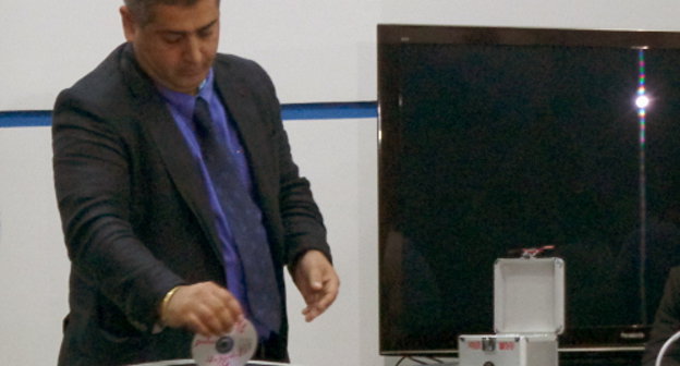 Cотрудник МВД уничтожает CD с файлами архива личной жизни граждан в аппарате "Шредер". Грузия, Тбилиси, 5 сентября 2013 г. Фото Инны Кукуджановой для "Кавказского узла"