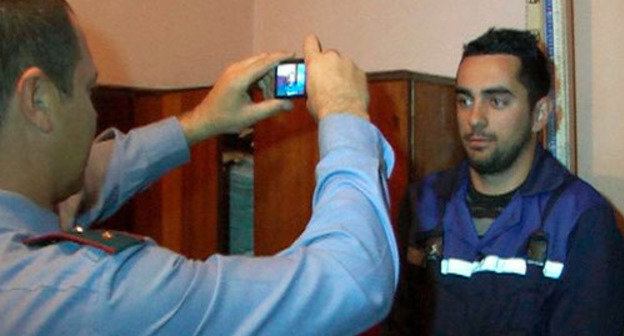 Сотрудник полиции фотографирует задержанного за нарушение миграционных правил. Сочи, 2012 г. Фото: Официальный сайт УВД города Сочи, http://suvd.ru