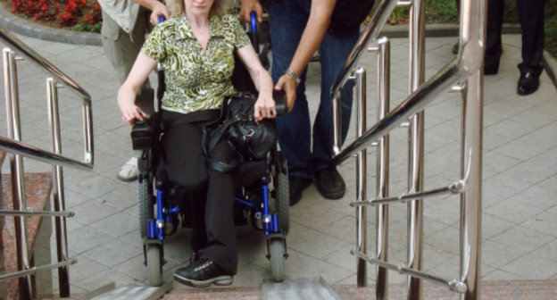 Жительница Сочи в инвалидной коляске пытается попасть в здание мэрии по излишне крутому пандусу. 2010 г. Фото Светланы Кравченко для "Кавказского узла"