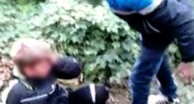 Кадр из видеоролика, размещенного на Youtube, на котором запечатлено избиение подростка сверстниками.