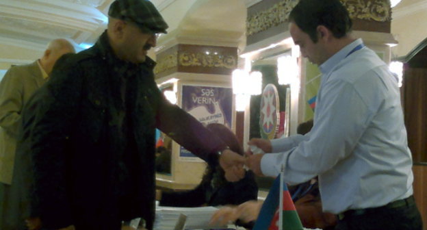 На избирательном участке №18 во время голосования на выборах президента Азербайджана. Член избирательной комиссии проводит маркировку. Баку, 9 октября 2013 г. Фото Григория Шведова для "Кавказского узла"