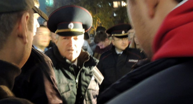 Сотрудники полиции беседуют с группой националистов, собравшихся вечером 14 октября на Театральной площади Краснодара для проведения акции в поддержку требований схода в Бирюлево. Фото Натальи Дорохиной для "Кавказского узла"
