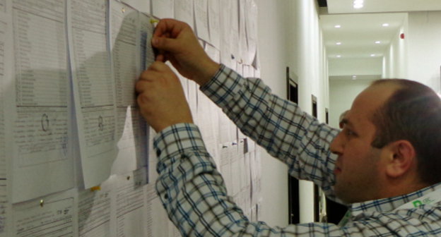Работник ЦИК Грузии прикрепляет к стене копии итоговых
протоколов, полученных из избирательных участков. Тбилиси, 27 октября 2013 г. Фото Инны Кукуджановой для "Кавказского узла"
