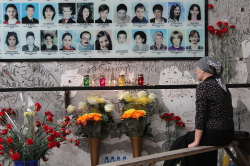 Женщина возле фотографий погибших во время теракта. Беслан, 1 сентября 2012 г. Фото Эммы Марзоевой для "Кавказского узла"