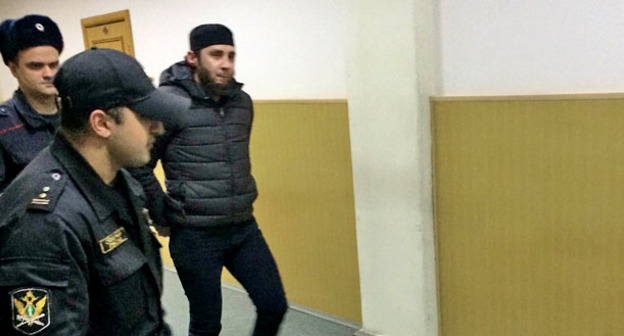 Заура Дадаева ведут по коридору суда. Фото Юлии Буславской для "Кавказского узла"