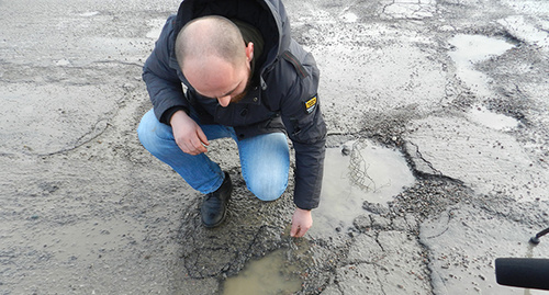 Участник акции демонстрирует состояние дорожного полотна. Фото Татьяны Филимоновой для "Кавказского узла" Участник акции демонстрирует состояние дорожного полотна. Фото Татьяны Филимоновой для "Кавказского узла"