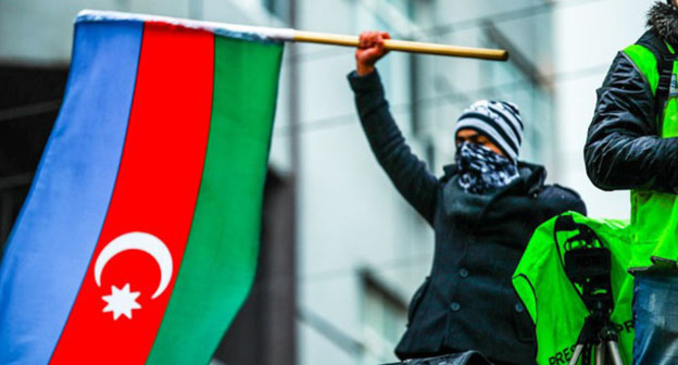 Участник митинга держит в руках флаг Азербайджана. Декабрь 2013 г. Фото Азиза Каримова для "Кавказского узла"