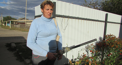 Жительница дома на улице Советская Елена Безверхова показывает свой бесполезный шланг для полива и пересохший огород