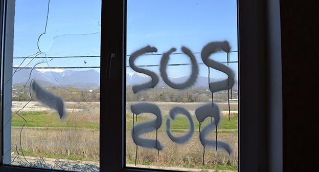 Надпись SOS на стекле. Поселок для переселенцев олимпиады "Веселое-Псоу" на границе с Абхазией. Фото Светланы Кравченко для "Кавказского узла"