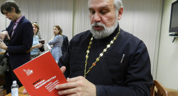председатель комиссии старший священник местной религиозной организации "Приход храма Иоанна Предтечи Волгограда", протоиерей Олег Кириченко показывает брошюру. Волгоградская область, 31 октября 2016 г. Фото Татьяны Филимоновой для "Кавказского узла"