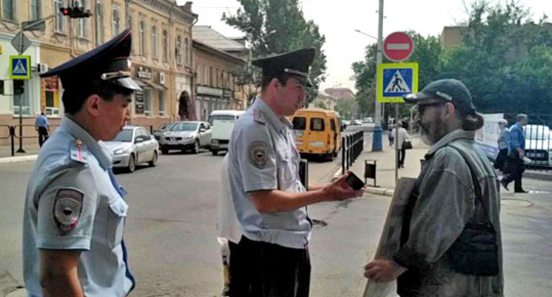 Сотрудники полиции проверяют документы у участника пикета в поддержку Навального. Астрахань, 17 мая 2017 г. Фото Елены Гребенюк для "Кавказского узла"