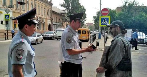 Сотрудники полиции проверяют документы у участника пикета в поддержку Навального. Астрахань, 17 мая 2017 г. Фото Елены Гребенюк для "Кавказского узла" Сотрудники полиции проверяют документы у участника пикета в поддержку Навального. Астрахань, 17 мая 2017 г. Фото Елены Гребенюк для "Кавказского узла"