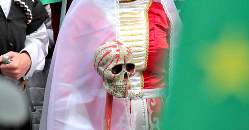 Участница акции держит насаженный на кол муляж черепа, облитый краской и символизирующие преступления генералов царской армии. Стамбул, 21 мая 2017 г. Фото Магомеда Туаева для "Кавказского узла"