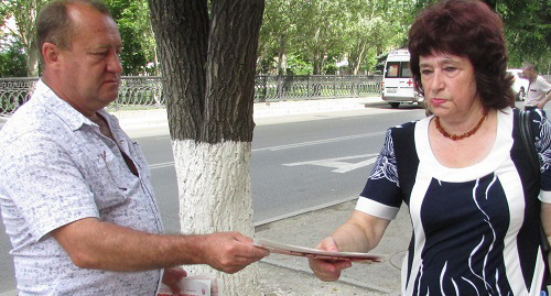 Участник пикета в рамках всероссийской акции "АнтиНАТО-Антикап" раздает прохожим агитационные листовки. Волгоград, 15 июля 2017 года. Фото Вячеслава Ященко для "Кавказского узла".