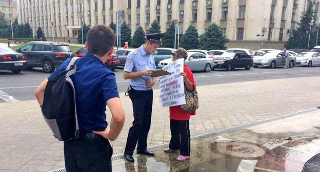 Сотрудник полиции общается с участницей одиночного пикета дольщиков ЖК "Анит-сити". Краснодар, 7 августа 2017 г. Фото Светланы Кравченко для "Кавказского узла"