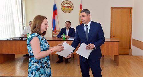 Вручение первых жилищных свидетельств гражданам, пострадавшим в результате теракта в сентябре 2004 года. Фото https://alaniatimes.ru/postradavshiie-v-tieraktie-2004-ghoda-nachali-poluchat-svidietielstva-na-priobrietieniie-zhilia/ Вручение первых жилищных свидетельств гражданам, пострадавшим в результате теракта в сентябре 2004 года. Фото https://alaniatimes.ru/postradavshiie-v-tieraktie-2004-ghoda-nachali-poluchat-svidietielstva-na-priobrietieniie-zhilia/