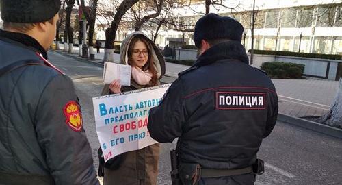Полицейский проверяет документы у участницы пикета. Краснодар, 24 декабря 2017 года. Фото Анны Грицевич для "Кавказского узла". Полицейский проверяет документы у участницы пикета. Краснодар, 24 декабря 2017 года. Фото Анны Грицевич для "Кавказского узла".