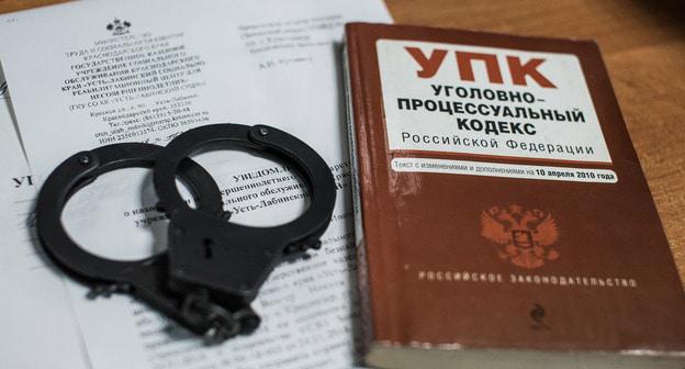 Наручники и Уголовный кодекс. Фото Елены Синеок, "Юга.ру"