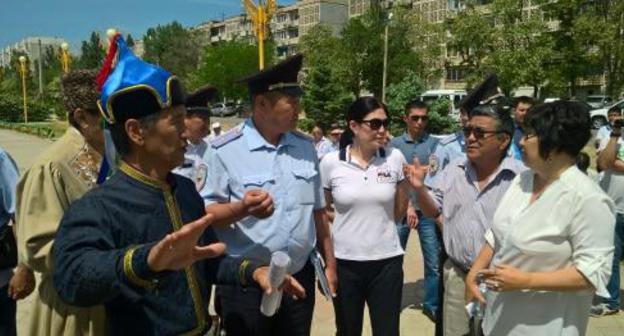 Заместитель начальника полиции по охране общественного порядка УМВД России в Элисте Александр Амтеев (в форме) и представитель администрации Элисты Кермен Бадмаева (справа) требуют от Валерия Бадмаева (в национальном костюме) прекратить съезд. 19 мая 2018 года. Фото Бадмы Бюрчиева для "Кавказского узла"