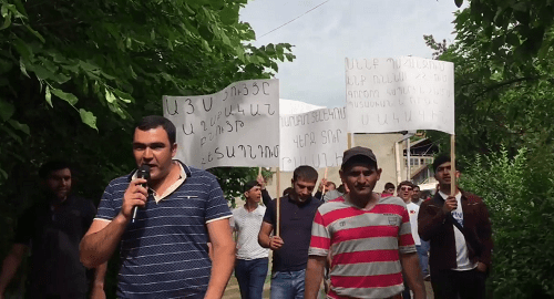 Жители Гадрута с плакатами направляются к офису "Карабах Телеком". Кадр видео https://www.facebook.com/armtimes.hy/videos/2070372493206705/
