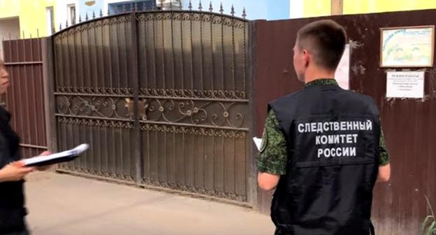 Сотрудники Следственного комитета возле ворот детского сада в Астрахани. Кадр из видео пользователя Punkt Astrakhan https://www.youtube.com/watch?v=CwcRpmQW7K0