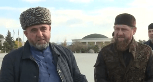 Человек, названный "представителем тейпа Нальгиевых", рядом с Рамзаном Кадыровым. Кадр видеосюжета ЧГТРК "Грозный". https://www.youtube.com/watch?v=hGRTXdrqXMw