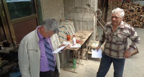 Петр Карпюк (справа) и его сосед читают повестку в суд. Фото Светлана Кравченко для "Кавказского узла".