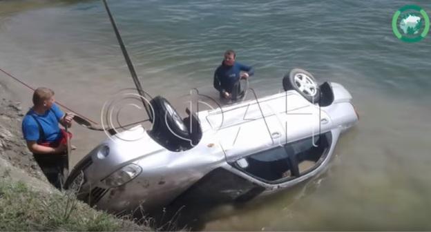 Спасатели достают автомобиль из воды. Скриншот с видео "Автомобиль «улетел» в Дон под Ростовом — пять человек погибло. ФАН-ТВ" https://www.youtube.com/watch?v=Rsko5JD9bR8