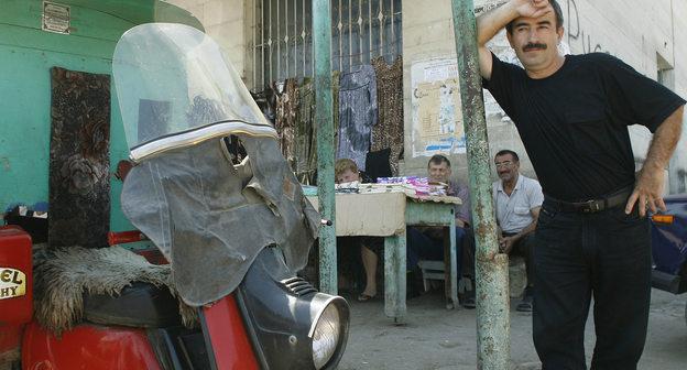 Мужчина стоит на рынке Дербента. 17 августа 2007 года. Фото: REUTERS/Thomas Peter