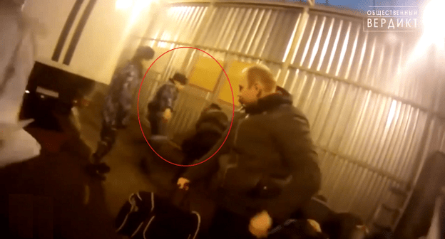 Сотрудник колонии бьет ногой заключенного Хасдина Муртазалиева. Кадр видео "Общественного вердикта". https://www.youtube.com/watch?v=MWVwt7vYPpg