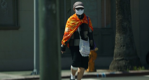 Женщина в маске. Фото: REUTERS/Mario Anzuoni