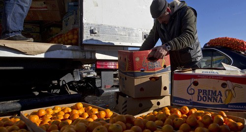 Продавец сортирует мандарины на рынке. Абхазия. Фото: REUTERS/Maxim Shemetov