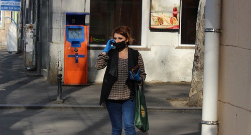 Женщина в защитной маске и перчатках на улице в Тбилиси. 16 апреля 2020 года. Фото Инны Кукуджановой для "Кавказского узла"
