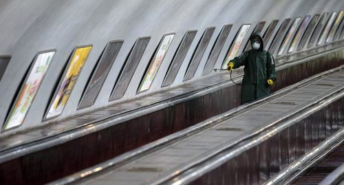 Дезифнекция экскалатора метро в Тбилиси. Фото  REUTERS/Irakli Gedenidze 