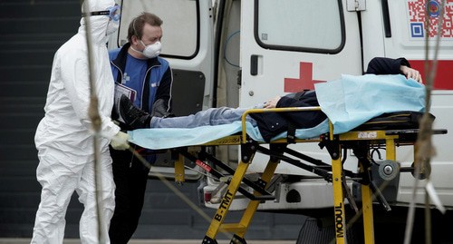 Медицинские работники и пациент возле машины скорой помощи. Фото: REUTERS/Tatyana Makeyeva