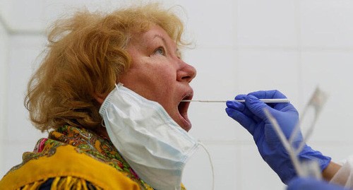 Женщина во время теста на коронавирус. Фото: REUTERS/Maxim Shemetov