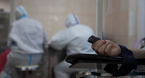 Рука пациента и медицинские работники. Фото: REUTERS/Maxim Shemetov